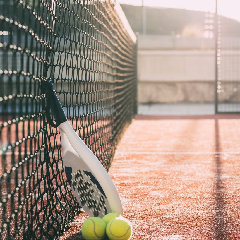Padel blade racket resting on the net